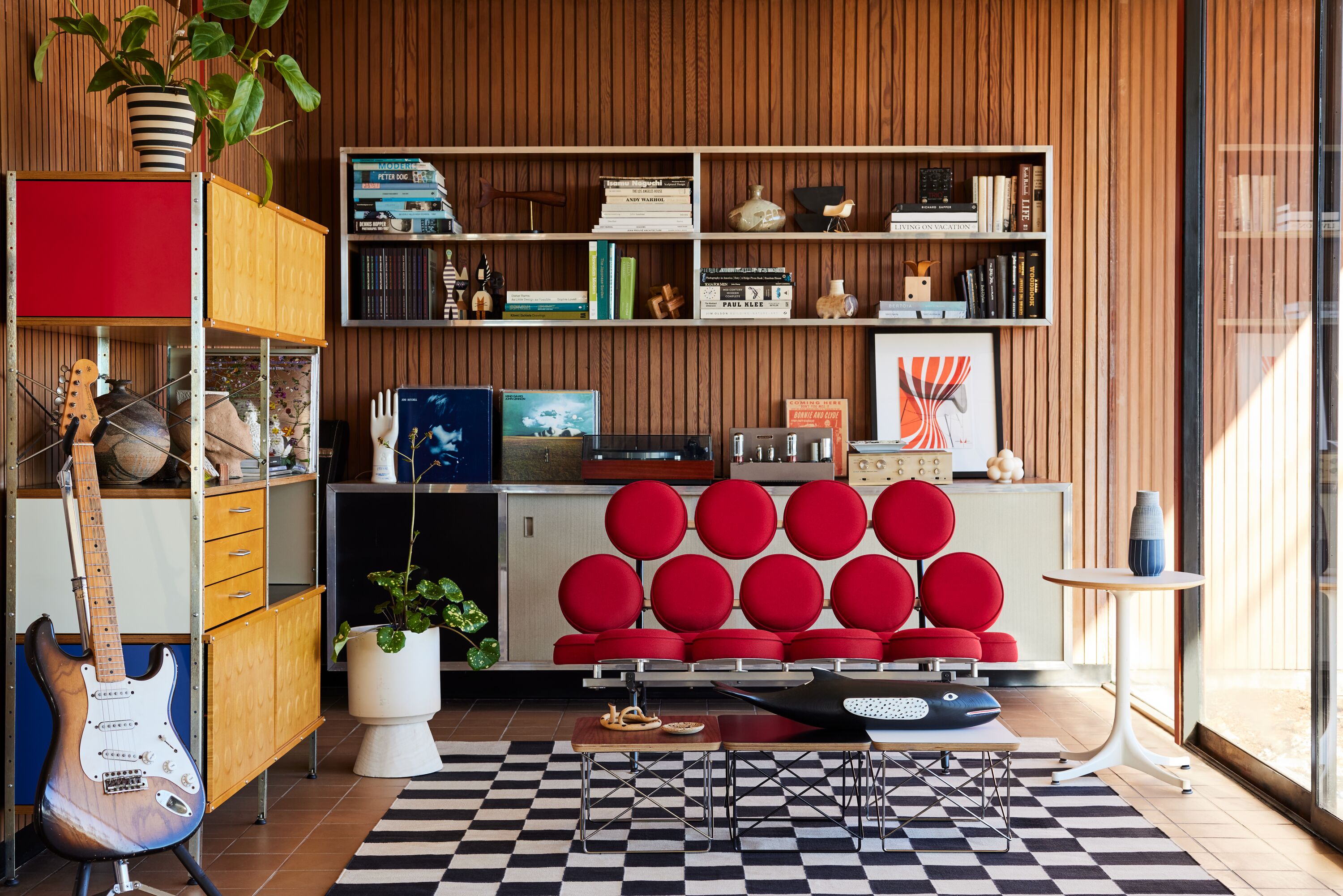 An AbakEnvironments Desk with a walnut top and polished legs, with a graphite Aeron Chair in a light home office setting and Folk Ladder Shelving.