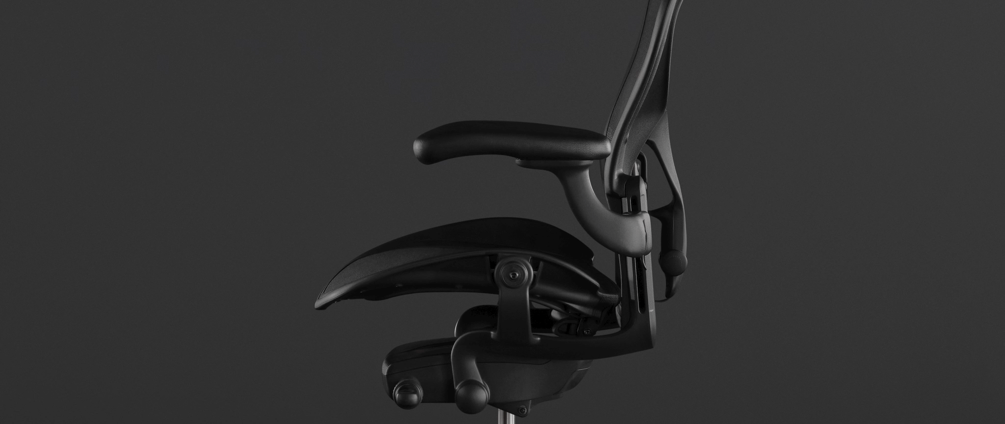 Rear view of a graphite Aeron office chair, showing back support and adjustable arms.