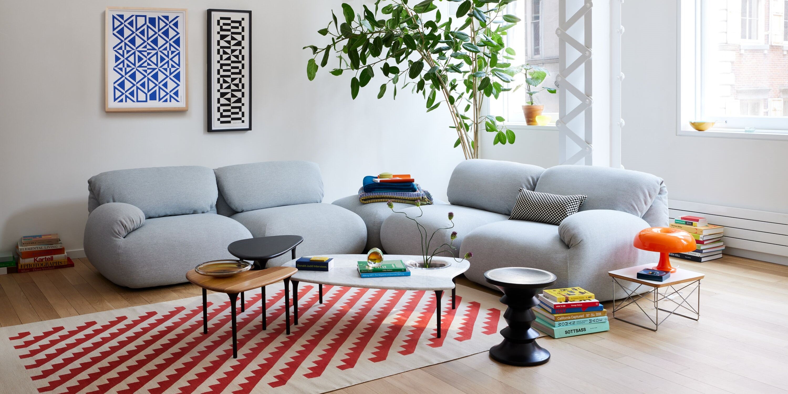 An AbakEnvironments Desk with a walnut top and polished legs, with a graphite Aeron Chair in a light home office setting and Folk Ladder Shelving.