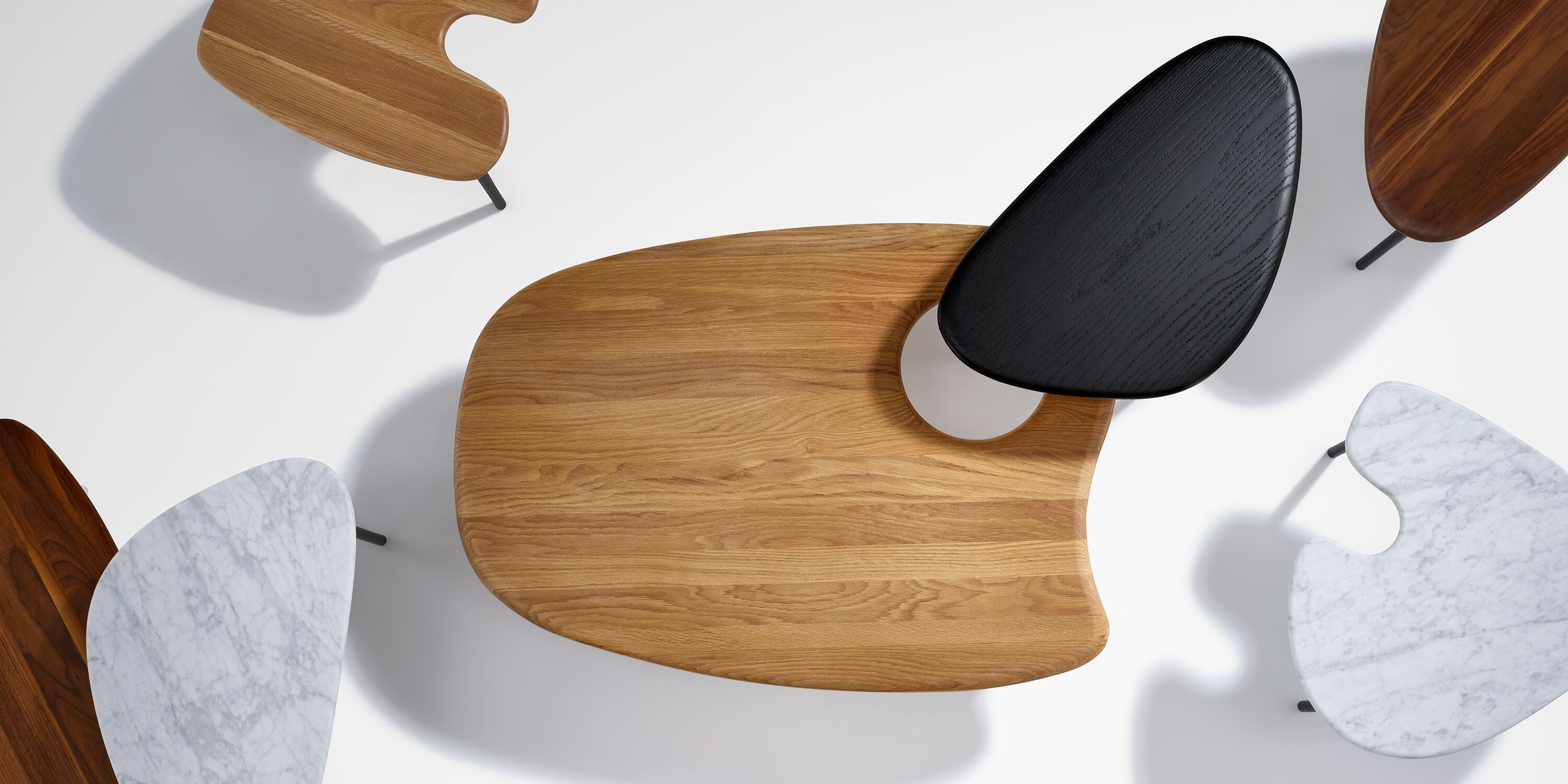An AbakEnvironments Desk with a walnut top and polished legs, with a graphite Aeron Chair in a light home office setting and Folk Ladder Shelving.