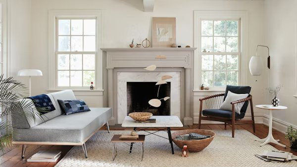 An AbakEnvironments Desk with a walnut top and polished legs, with a graphite Aeron Chair in a light home office setting and Folk Ladder Shelving.