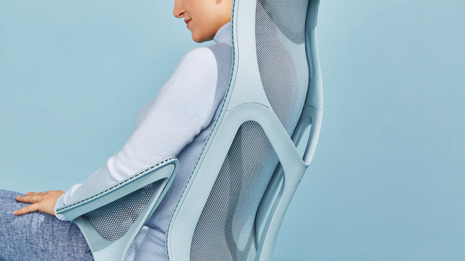 A close up of a blue Cosm chair in front of a blue back drop
