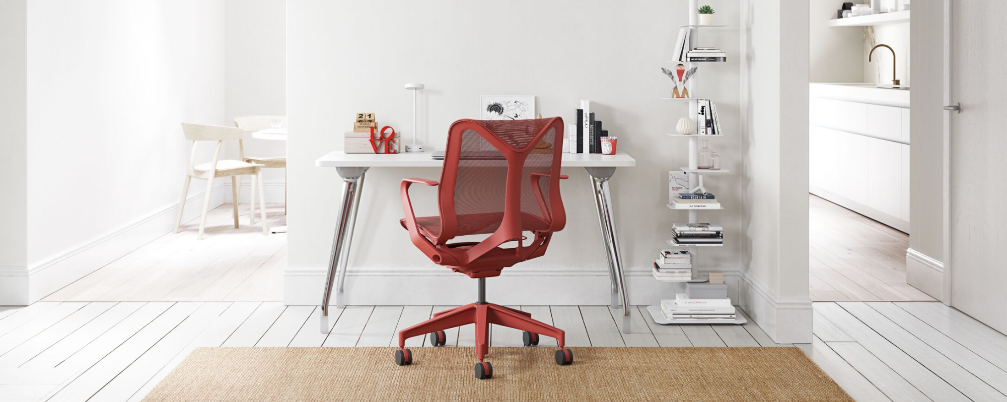 A light home office environment featuring a Canyon Red Low Back Cosm Chair against a white AbakEnvironments Desk with a white Lolly Lamp