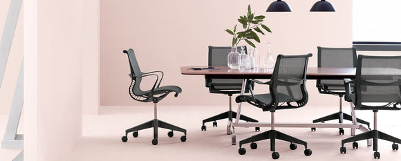 Graphite Setu chairs gathered around a large meeting table.